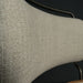 Close-up of a textured beige chair backrest on a dark background