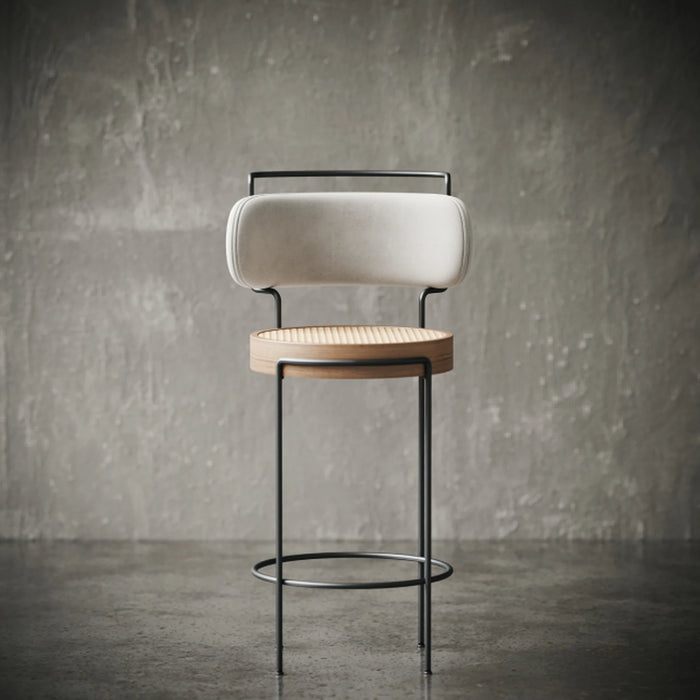 Modern bar stool with cushioned seat and backrest against a textured wall.