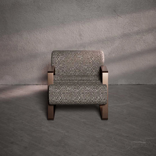 Patterned armchair against a textured gray wall