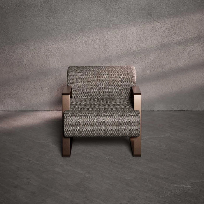 Patterned armchair against a textured gray wall