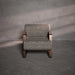 Patterned armchair against a textured gray wall