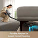 Person using a vacuum cleaner with a flexible adapter to clean under a sofa.
