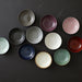 Collection of ceramic plates in various colors on a dark surface