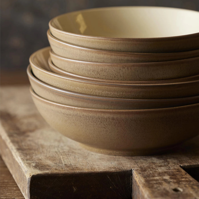 Stack of brown ceramic bowls on a wooden surface