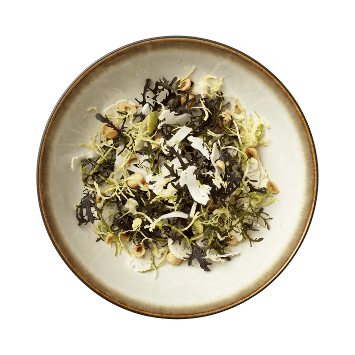 Plated dish of seaweed salad on a white plate with a green background