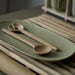 Wooden spoons on a green plate with a blurred background