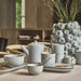 Ceramic tea set on a table with decorative elements