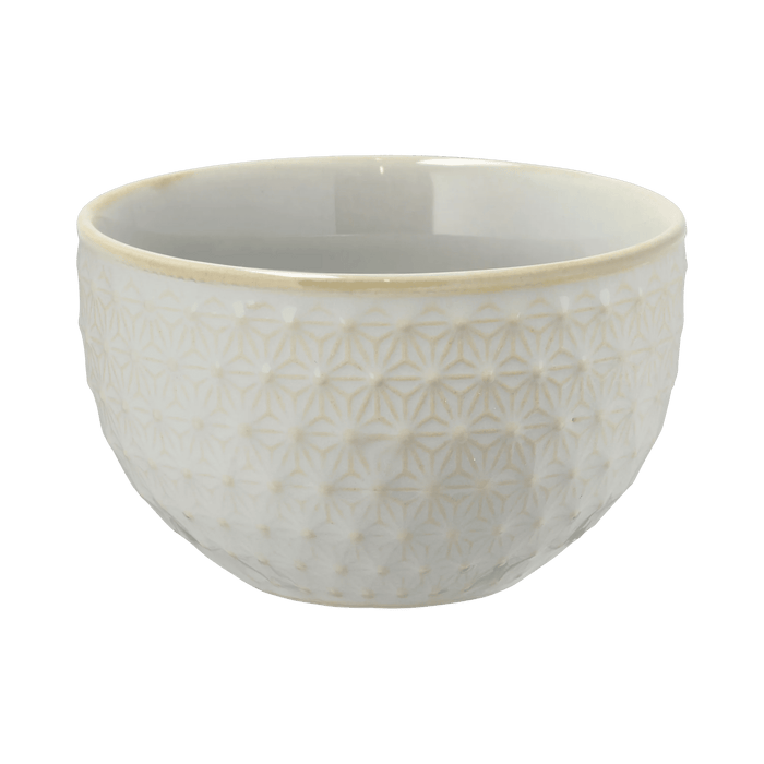 White ceramic bowl with textured design on a green background