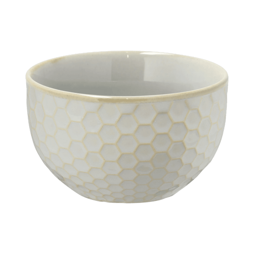 White ceramic bowl with honeycomb pattern on a green background