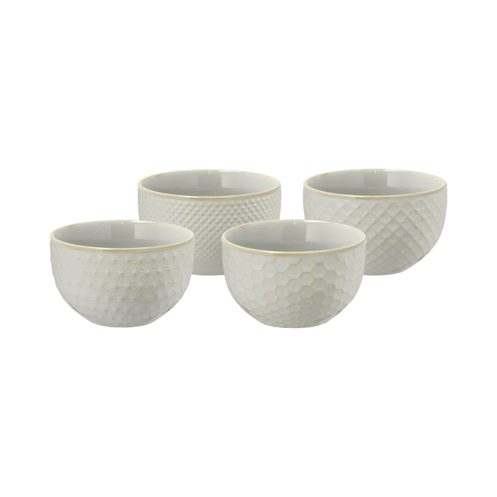 Set of four white textured bowls on a green background