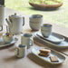 Set of ceramic tea set on a wooden table with natural light
