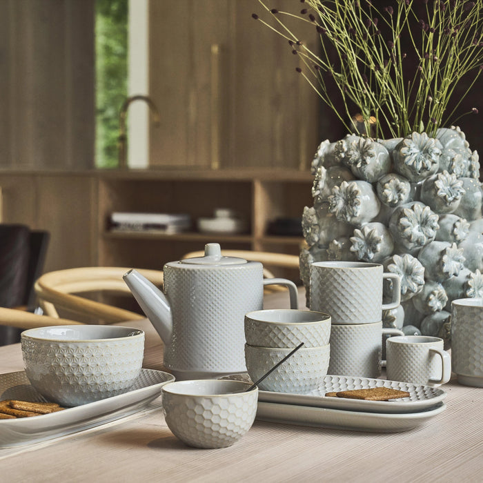 Ceramic tea set on a table with decorative elements