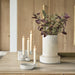 Decorative setup with a vase of flowers and candle holders on a wooden surface.