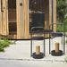 Black outdoor stools with candles in front of a wooden cabin.