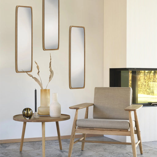 Modern living room with a beige armchair, side table, and wall mirrors.
