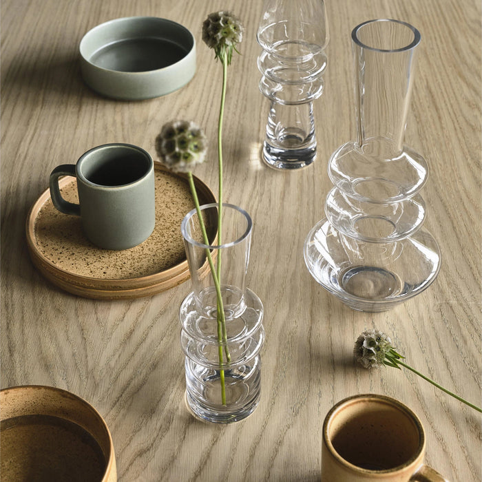 Table setting with cups, mugs, and glassware on a wooden surface