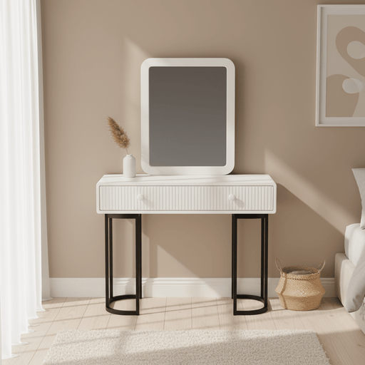 White vanity table with mirror against a beige wall in a room.