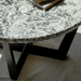 Marble-top coffee table with black legs on a neutral background