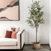 Living room with a white sofa, decorative pillows, and a potted plant.