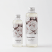 Two fragrance diffusers with floral design labels on a white background