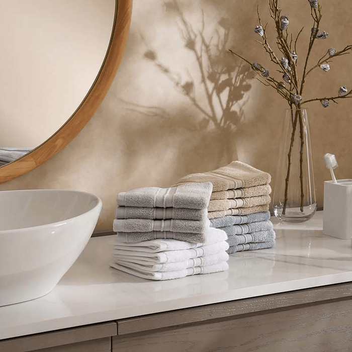 Stack of folded towels on a bathroom counter with a mirror and decorative elements.