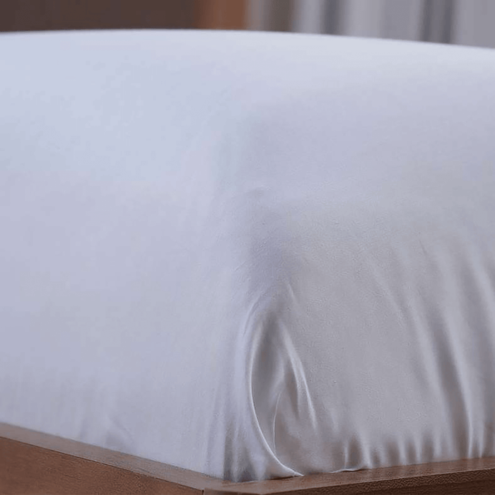 White fitted sheet on a wooden bed frame
