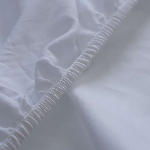 Close-up of white fitted sheet with subtle texture and stitching details.