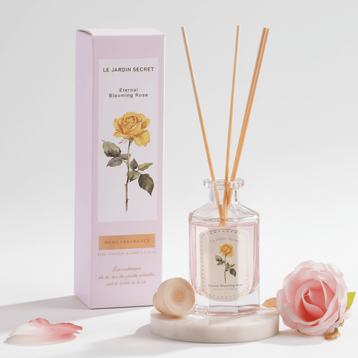 Reed diffuser set with packaging and floral elements on a light background