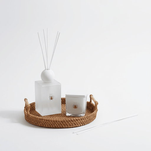 Decorative items including a diffuser, candle, and decorative tray on a white background