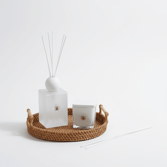 Decorative items including a diffuser, candle, and decorative tray on a white background