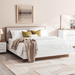 Neatly made bed with white bedding and decorative pillows in a bedroom setting.