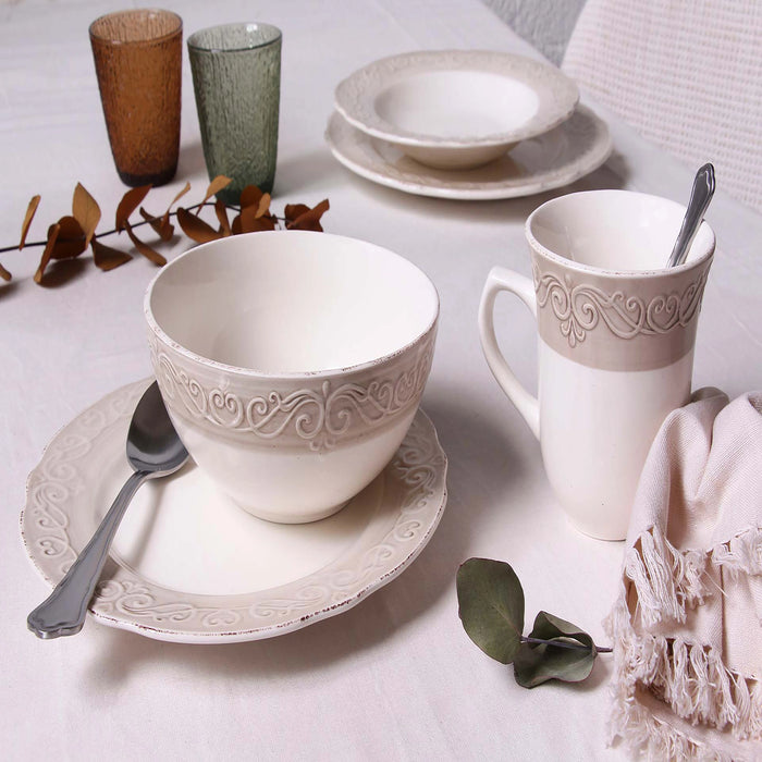 Ceramic tableware set with cups, bowls, and plates on a light surface.