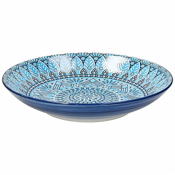 Blue ceramic bowl with intricate white patterns on a white background