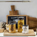 Three glass jars with decorative text on a wooden cutting board in a kitchen setting.
