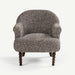 A single upholstered accent chair with a rounded back, rolled arms, and dark turned wooden legs, shown against a plain light gray studio background.