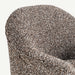 Close-up of a textured upholstered armchair showing the fabric weave in a speckled brown, beige, and white pattern against a light off-white background.