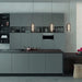 Modern kitchen with dark green cabinets and black countertops