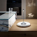 Modern lamp on a wooden table with a kitchen background