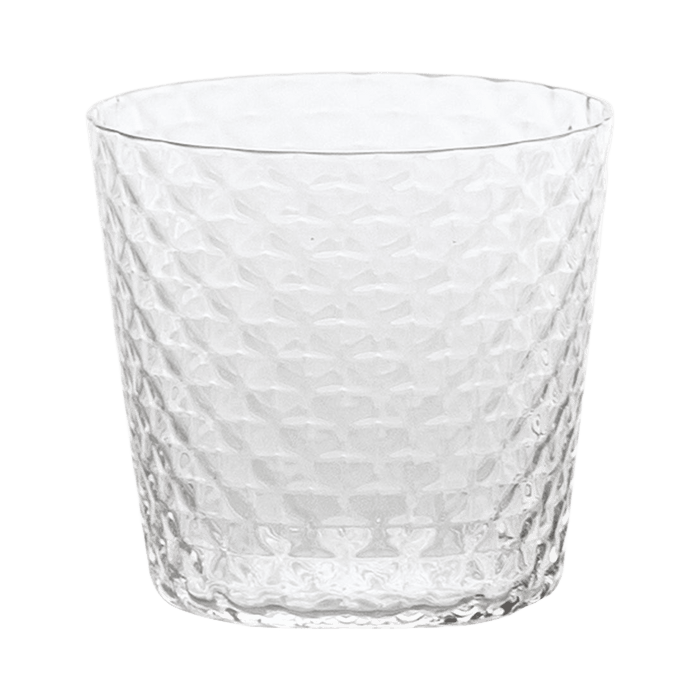 Clear textured glass tumbler on a green background