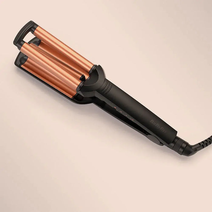 Hair straightener with copper coils on a beige background