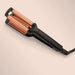 Hair straightener with copper coils on a beige background