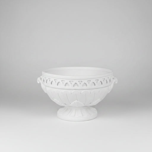 White decorative bowl with intricate patterns on a light gray background