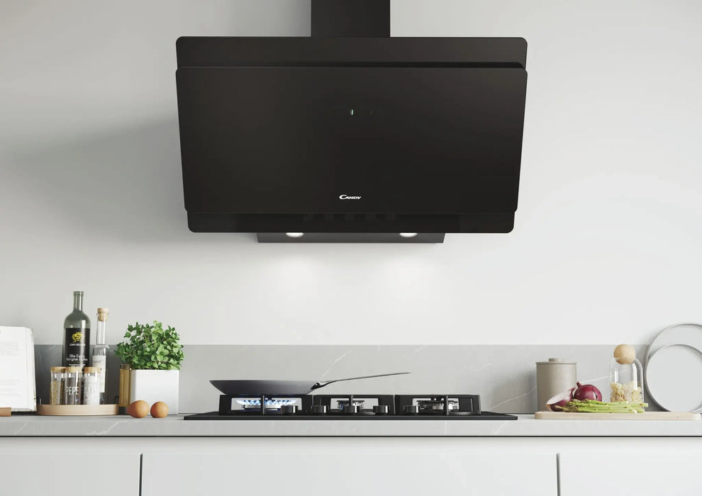 A matte black modern range hood mounted above a gas stovetop in a clean, minimalist kitchen setting with white cabinetry and light gray walls.