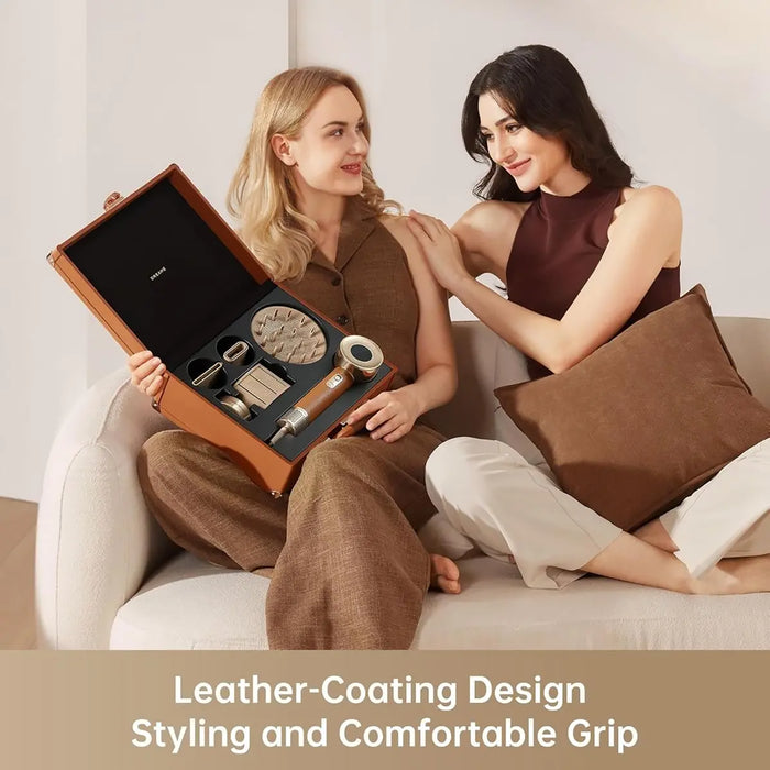 Two women sitting on a couch with a leather-coated product box.