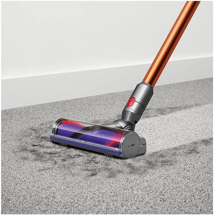 Vacuum cleaner on a carpeted floor with a white wall background