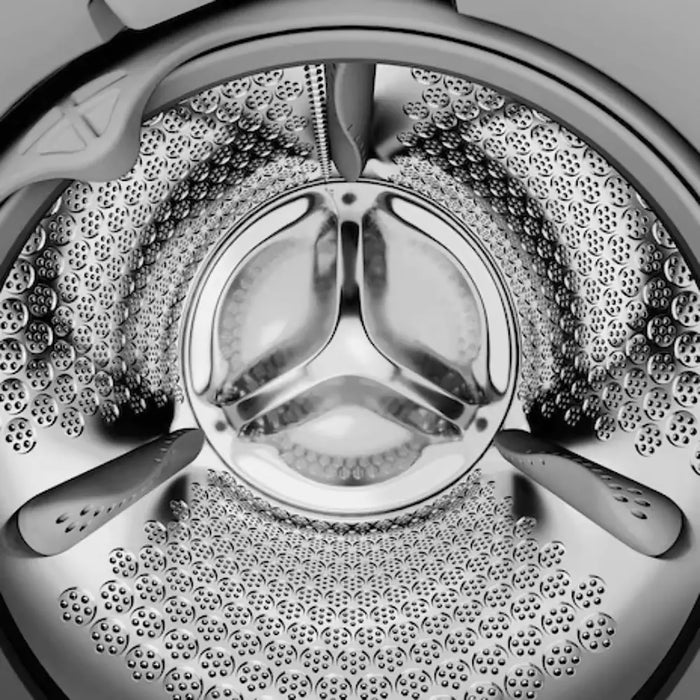 Close-up of a washing machine drum with water and bubbles