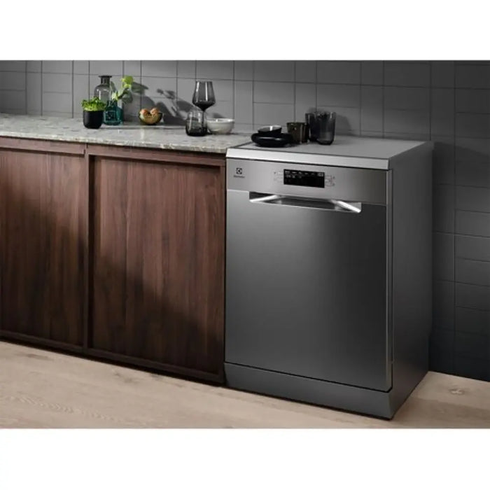 Dishwasher in a kitchen setting with wooden cabinets and a tiled wall.