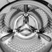 Close-up of a washing machine drum with bubbles and a Mercedes-Benz logo.