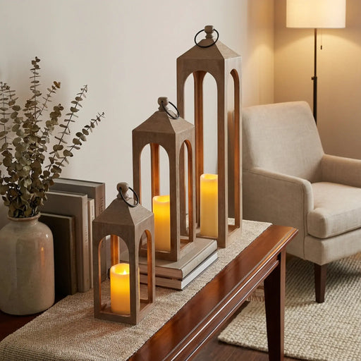 Decorative wooden lanterns with candles on a table in a living room setting.