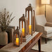 Decorative wooden lanterns with candles on a table in a living room setting.